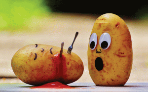 Potato with googly eyes horrified at seeing his dead friend stabbed with a fork and bleeding ketchup