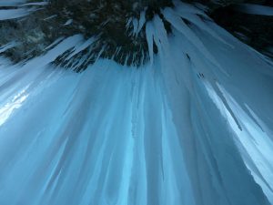 An upward-facing shot of long icicles in a cave