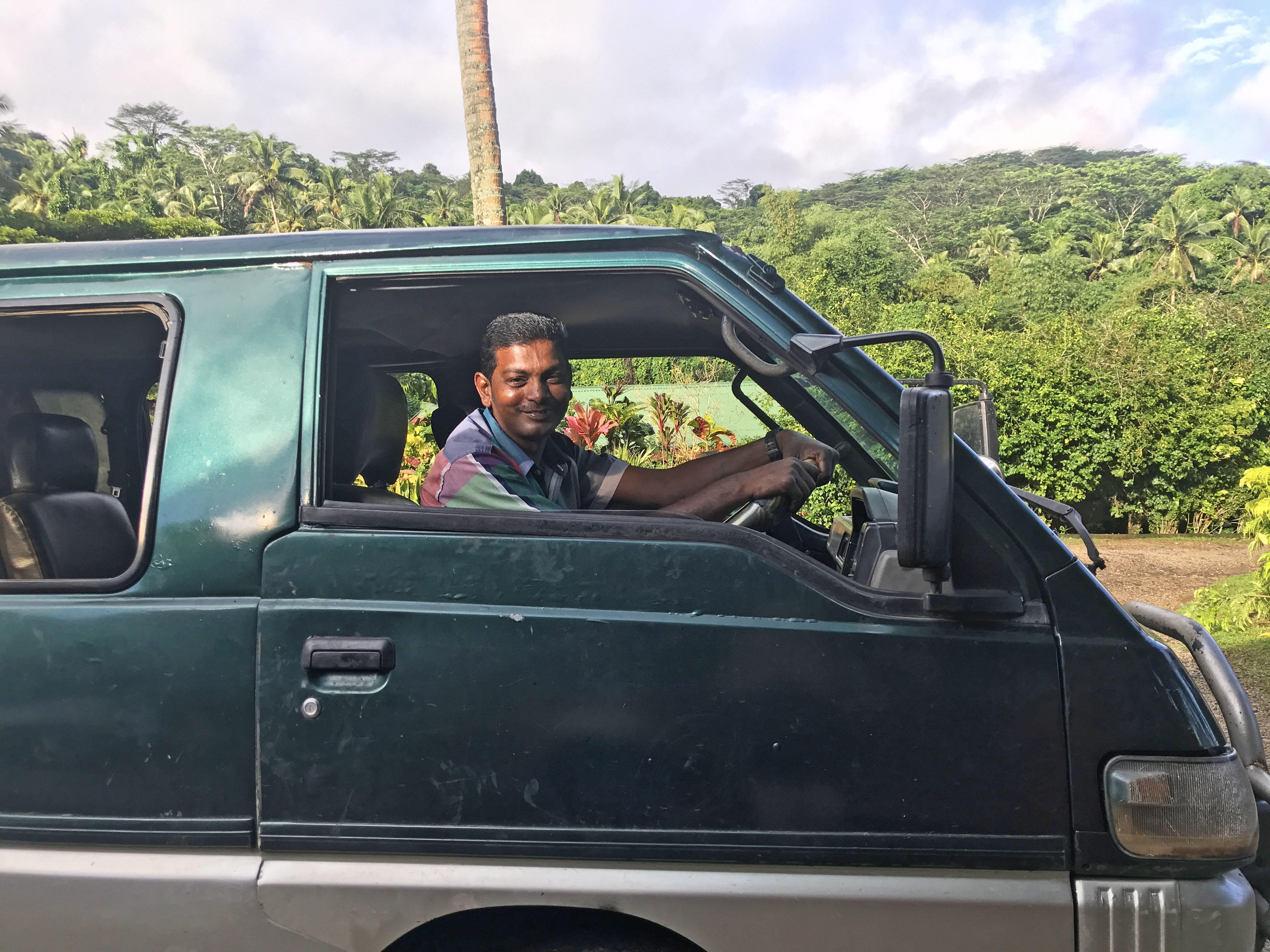 A kind man from Fiji, smiling from inside his car