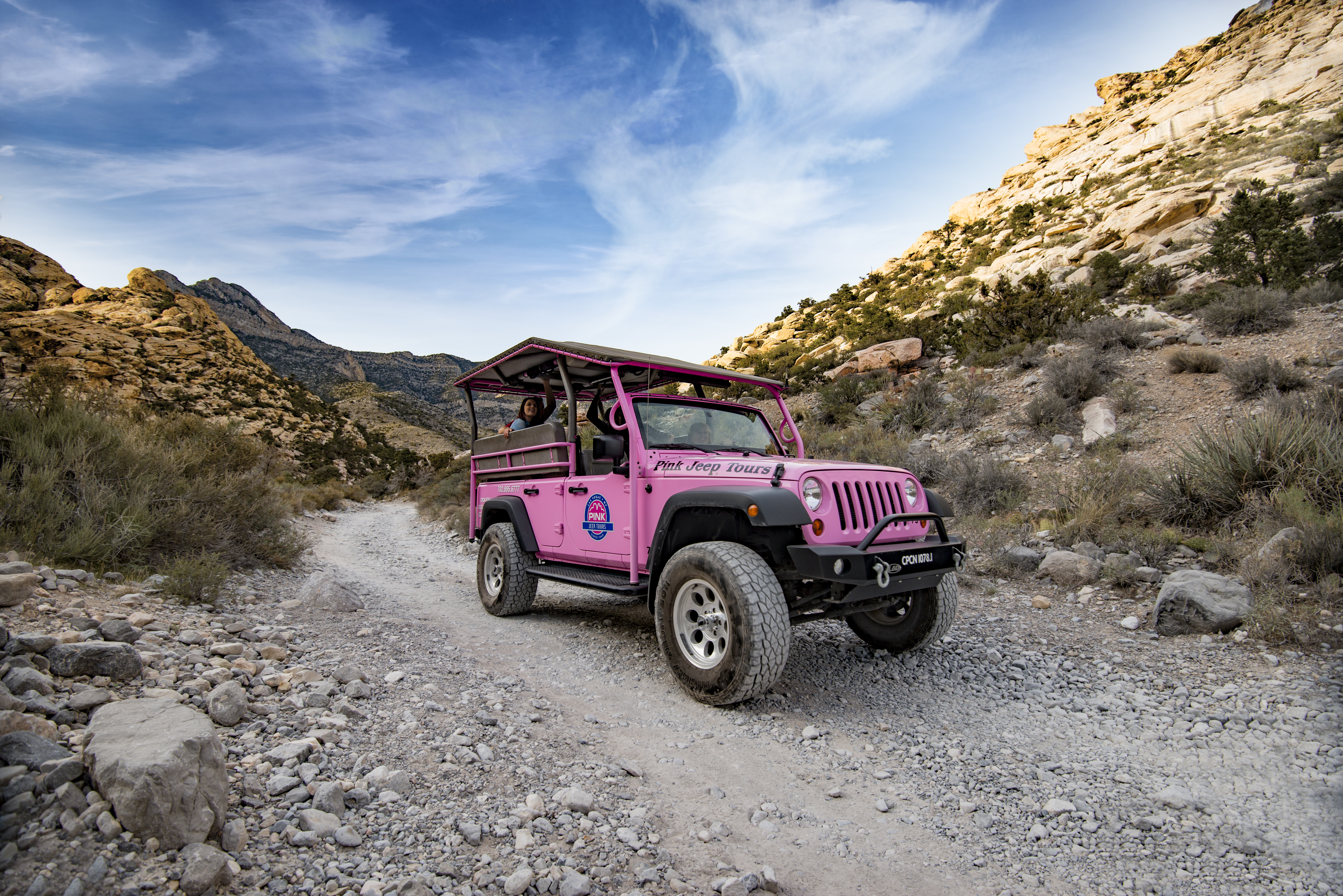 A pink jeep on a gravel trail